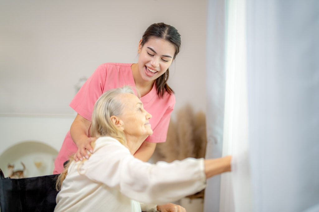 Alltagsbegleitung in Bochum durch eine Betreuungskraft bei der Unterstützung einer Seniorin am Fenster